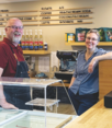 Local business owners smiling in their coffee shop.