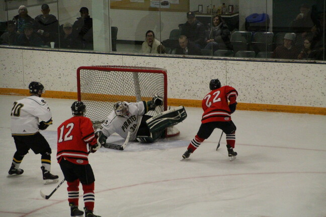 Pirates hockey action shot at goalie.