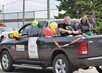 Parade truck float with balloons with Mayor Tony Mycock and spouse riding in the cab, smiling and waving. 